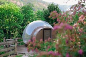 a dome shaped building on a wooden bridge at Maso La Marianna Bubble Glamping in Trentino in Sant'Orsola Terme