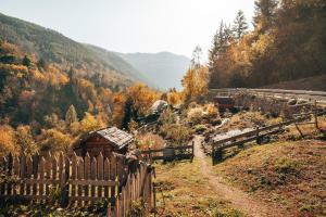 a wooden fence on a hill with a mountain at Maso La Marianna Bubble Glamping in Trentino in Sant'Orsola Terme