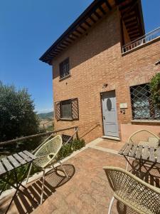 a patio with chairs and a table and a door at AFFITTACAMERE Casale Le Civette in Montepulciano