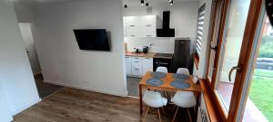a small kitchen with a wooden table and chairs at Rabka Serenity in Rabka-Zdrój