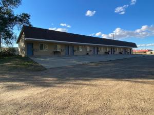 a building with a large driveway in front of it at Malta Edgewater Inn and RV Park in Malta