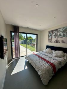 ein Schlafzimmer mit einem großen Bett und einem großen Fenster in der Unterkunft Villa in Sainte-Eulalie