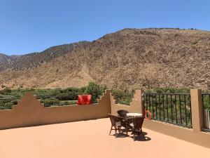 a balcony with two chairs and a table and a mountain at Gite Berber Home in Azal