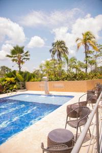 una piscina con sedie e palme di Amaranthus Renaissance a Doradal