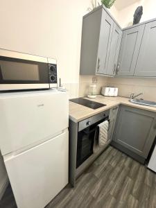Una pequeña cocina con microondas y nevera. en The Valley View Apartment, en Great Harwood 2 fotos más