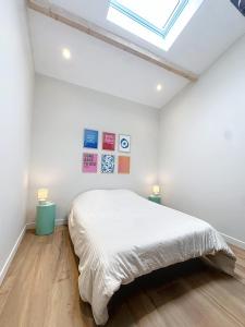 a white bedroom with a bed and a skylight at Maison à 2 min de la plage Saint Georges de Didonne in Saint-Georges-de-Didonne