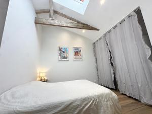 a white bedroom with a bed and a window at Maison à 2 min de la plage Saint Georges de Didonne in Saint-Georges-de-Didonne