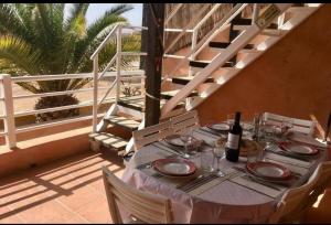 a table with a bottle of wine sitting on a patio at Duplex vue Océan in Costa de Antigua
