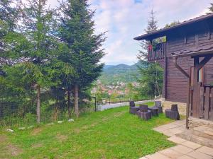 a yard with chairs and a building with a view at Panoramic Chalet in Vişeu de Sus