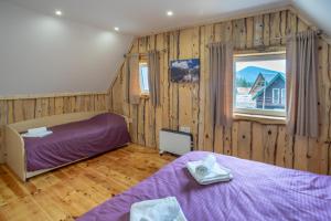 a bedroom with two beds and a window at Sunny Village - Vila Rabbit in Žabljak