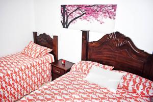 a bedroom with two beds and a table with a lamp at Best location Big 3 Bdrs, Fully Stocked and A/C in Ensanche Quisqueya