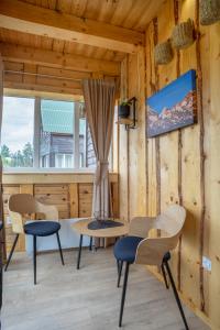 a room with a table and chairs and a window at Sunny Village - Vila Rabbit in Žabljak