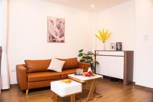 a living room with a couch and a table at East West Apartment Hanoi in Hanoi +35 photos