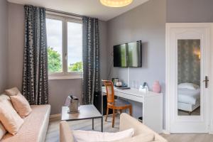 un soggiorno con divano e scrivania di Logis Auberge Saint Thégonnec & son Restaurant a Saint-Thégonnec