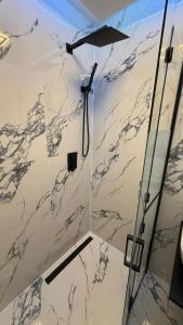 a bathroom with a shower with marble walls at Studio Poiana Brasov in Poiana Brasov