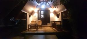 a room with a table and chairs at night at Lake Wind in Habarana