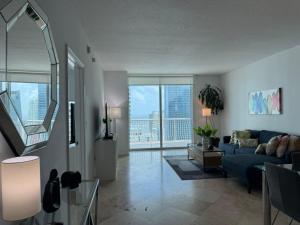 マイアミにあるAmazing apartment in the Heart of Brickellの青いソファと大きな窓のあるリビングルーム +70枚の写真