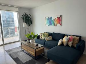 マイアミにあるAmazing apartment in the Heart of Brickellの青いソファとコーヒーテーブルのあるリビングルーム