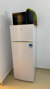 a microwave sitting on top of a white refrigerator at Studio Poiana Brasov in Poiana Brasov