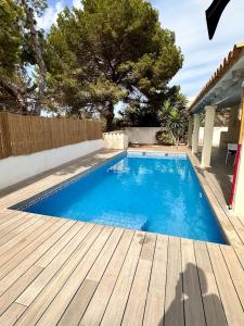 a swimming pool next to a wooden deck at Villa Love, ET4013 in Es Pujols