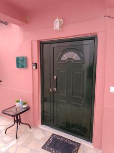 a black door in a pink wall with a table at LA CASA Di GIORGIO in Pentátion