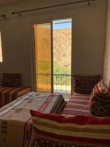a bedroom with two beds and a large window at Gite Berber Home in Azal
