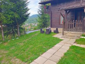 a house with a yard with chairs in front of it at Panoramic Chalet in Vişeu de Sus +14 photos