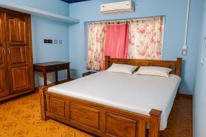 a bedroom with a large bed and a window at Evergreen Homestay in Kollengode