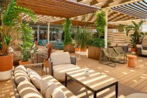 a patio with a couch and tables and plants at Radisson Blu Resort & Spa in Split