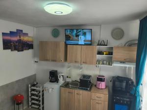 a kitchen with a refrigerator and a tv on the wall at Home MARIA in Orşova +17 photos