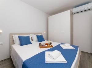 a bedroom with a large bed with blue and white pillows at Apartment Kurte in Nerežišća
