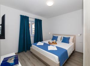 a bedroom with a large bed with blue curtains at Apartment Kurte in Nerežišća