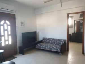 a living room with a couch next to a door at Kanari Holiday Home in Gourna