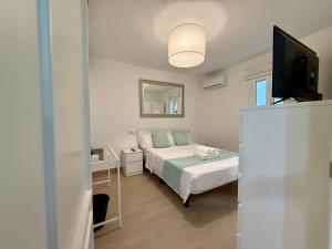 a small bedroom with a bed and a television at 3 Double Beds - Great Area, Perfect for Families in Seville