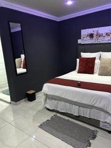 a bedroom with a large bed and a mirror at Okuhle Guesthouse Steelpoort in Steelpoort