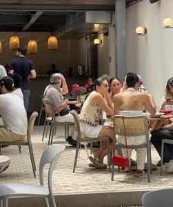 a group of people sitting at tables in a restaurant at Capybara Hostel Boutique - Villavicencio in Villavicencio