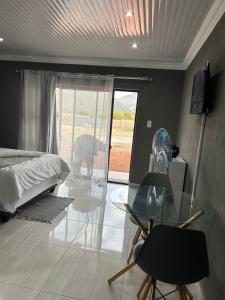 a bedroom with a bed and a glass table at Okuhle Guesthouse Steelpoort in Steelpoort