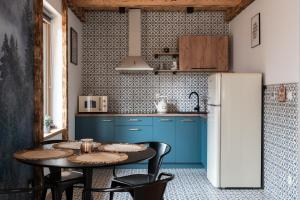 a kitchen with blue cabinets and a table with chairs at Domki Miętusówka in Dzianisz