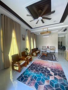 a living room with a colorful rug on the floor at Permai Homestay in Kampong Burok