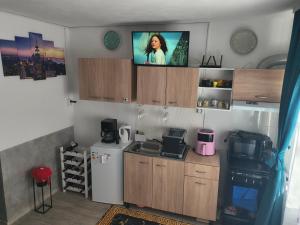 a small kitchen with a tv on the wall at Home MARIA in Orşova