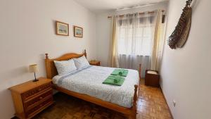 a bedroom with a bed and a window at Casa da Mãe in A dos Cunhados