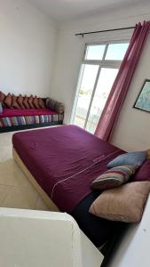 a large bed with pillows in a room with a window at Chambre privée au cœur de Rabat in Rabat +10 photos