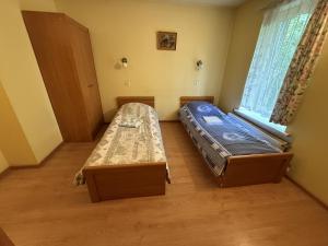 two beds in a room with a window at Viršutinė 9 4 kambarys in Klaipėda