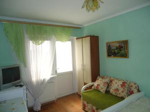 a bedroom with a window and a chair and a television at Гостевой дом у моря in Odesa