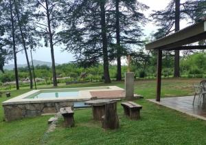 サンタ・ロサ・デ・カラムチタにあるEl Cobijo, Casas de Campoの庭にテーブルとベンチがあるプール