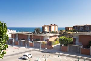 a white car parked in a parking lot in front of buildings at Villa Beach Barcelona in Montgat
