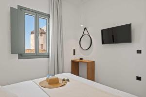 a room with a bed with a hat and a window at Vivlos Luxury Summer Houses in Vívlos