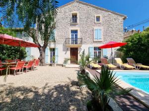 a villa with a swimming pool in front of a house at La maison des Vendangeurs 6 in Olonzac