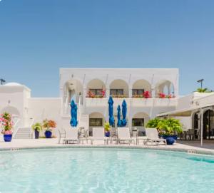 a pool in front of a building with chairs and umbrellas at Naples Dream at WTC with Heated Pool SPA Sauna 7 bicycles and 3 mls to beach in Naples