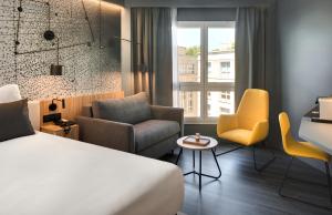 a hotel room with a bed and chairs and a window at Mercure Montpellier Centre Antigone in Montpellier +147 photos